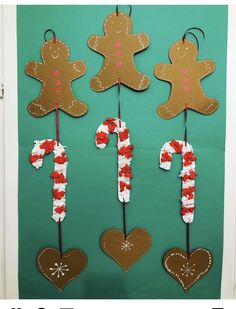 some gingerbreads and candy canes are hanging on a door with green background