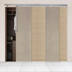 an open closet door with sliding doors and beige curtains on the side, in front of a white tiled floor