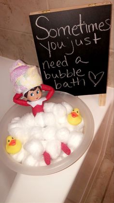 an elf in the bathtub with cotton balls and rubber ducks