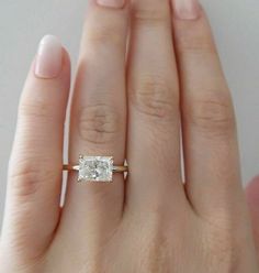 a woman's hand with an engagement ring on it