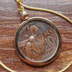 "Honeybee polinator antique Coin Pendant Necklace, 1920 Italian coinage, on a 24\" Smooth Gold Filled round chain. This is an original coin from Italy, from 1920, featuring our favorite little bug, busy as ever, the honeybee. This coin weighs 5.4 grams, has a diameter of 23 millimeters, and a thickness of 1.9 millimeters. It is a copper coin in its natural state, secure in a smooth gold-filled bezel with a reeded edge, on a smooth gold-filled snake chain. You can choose the chain length and make Vintage Coin Necklaces, Vintage Coin-shaped Brass Necklaces, Vintage Brass Coin Necklace With Round Pendant, Vintage Brass Coin Necklaces, Vintage Bronze Necklace With Coin Pendant, Handmade Vintage Brass Coin Necklace, Handmade Vintage Bronze Coin Necklace, Vintage Bronze Necklaces With Coin Pendant, Vintage Coin Shaped Locket Necklace