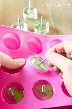 a child's hand is picking up leaves from an ice cream molding tray