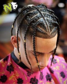 a young man with long box braids on his hair is looking down at the ground