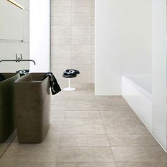 a bathroom with two sinks and a bathtub next to each other in front of a white wall