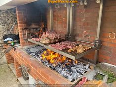 an outdoor grill with meats and vegetables cooking on it's sides, in front of a brick wall