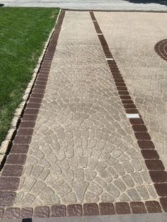 a red fire hydrant sitting on the side of a brick road next to grass