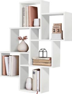 four white shelves with books and vases on each shelf, one is filled with books