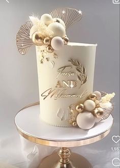 a white and gold wedding cake sitting on top of a table