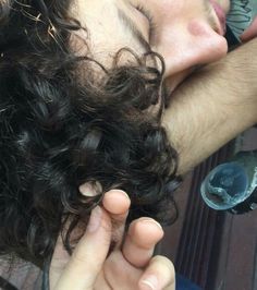 a close up of a person laying on the ground with his head resting on someone's hand