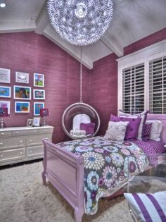 a bedroom decorated in purple and white with pictures on the wall