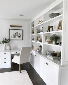 an instagram photo of a white home office with built - in bookcases