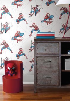 a spiderman wallpaper is next to an old dresser and lamp in the corner