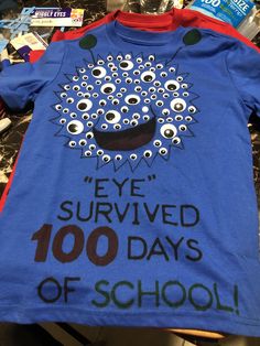 a blue t - shirt with eyeballs on it that says eye survived 100 days of school