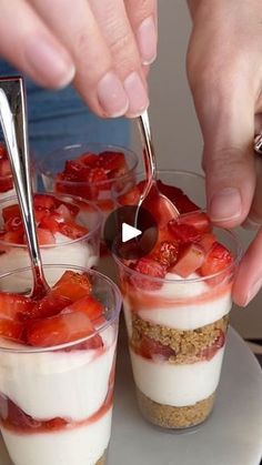 someone is spooning strawberries into small desserts