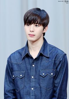 a young man with black hair and blue denim shirt