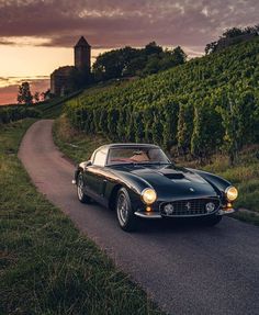 a classic car driving down a country road