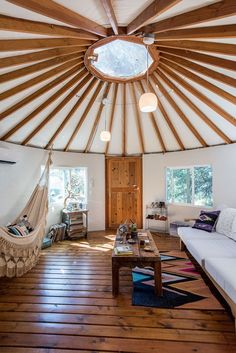 a living room filled with furniture and a wooden floor covered in wood planked walls