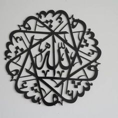 an arabic calligraphy is shown in the shape of a circle on a white wall