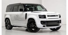 a white land rover is parked in a room with black rims on it's tires