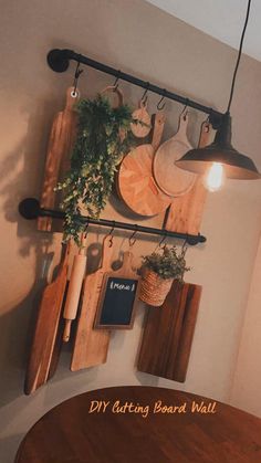 a wooden table topped with lots of cutting boards next to a wall mounted potted plant