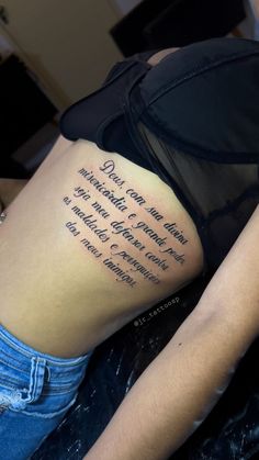 the back of a woman's stomach with a tattoo on it that reads,