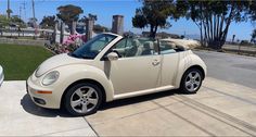 a white convertible car parked on the side of a road