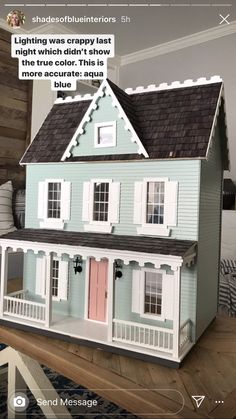 a doll house sitting on top of a wooden table