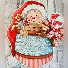 a handmade christmas card featuring a baby in a stroller with polka dots and a red bow