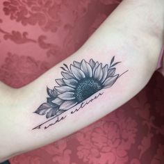 a woman's arm with a sunflower tattoo on the left side of her arm