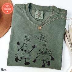 a green t - shirt with an image of two cartoon characters on it and a cowboy hat next to it