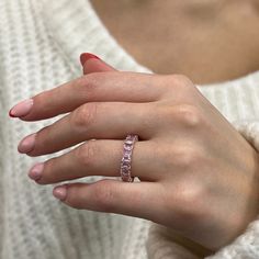 a woman's hand wearing a pink diamond ring