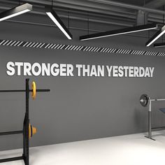 there is a sign that says stronger than yesterday on the wall in this gym