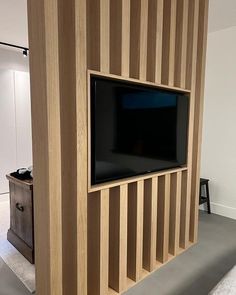 a flat screen tv mounted to the side of a wooden wall