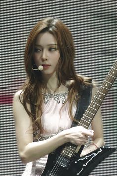 a woman with long hair holding a guitar