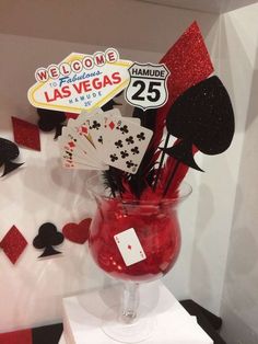 a vase filled with red liquid sitting on top of a white table next to a sign