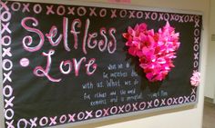 a blackboard with pink flowers on it that says selfless love