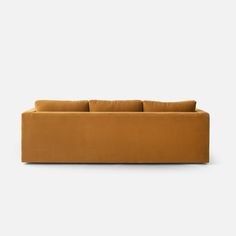 an orange couch sitting on top of a white floor