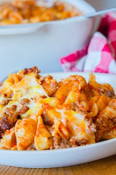 a white bowl filled with cheesy pasta and meat