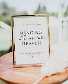 a sign that says dancing with us is in heaven on top of a wooden table