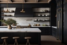 a kitchen with black cabinets and marble counter tops, gold pendants hanging from the ceiling