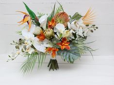 a bouquet of flowers on a white background with green leaves and orange orchids in the center