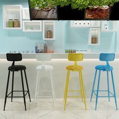 three different colored stools in front of a counter