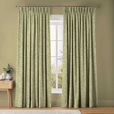 a living room with green curtains and a white rug