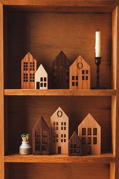 small wooden houses on shelves with a candle