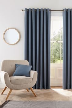 a living room with purple curtains and a chair