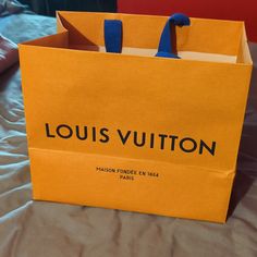 a louis vuitton bag sitting on top of a bed