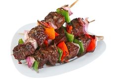 skewered meat and vegetables on a white plate