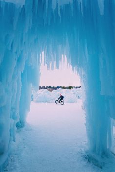 a person riding a bike through an ice cave