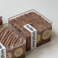 two plastic containers filled with brownies and banana slices on top of each other in front of a white background