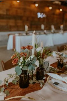 there are two vases with flowers on top of the table at this wedding reception